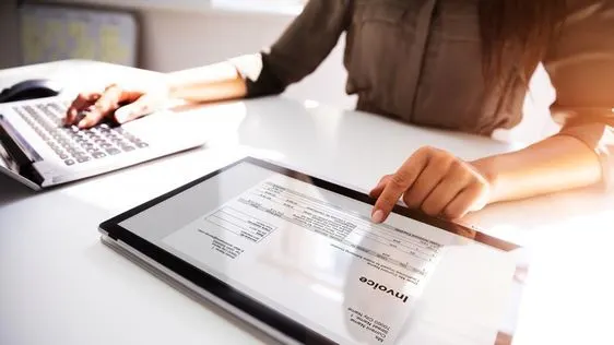 using computer to review or process e-invoice for SME business, enhancing digital invoicing compliance.
